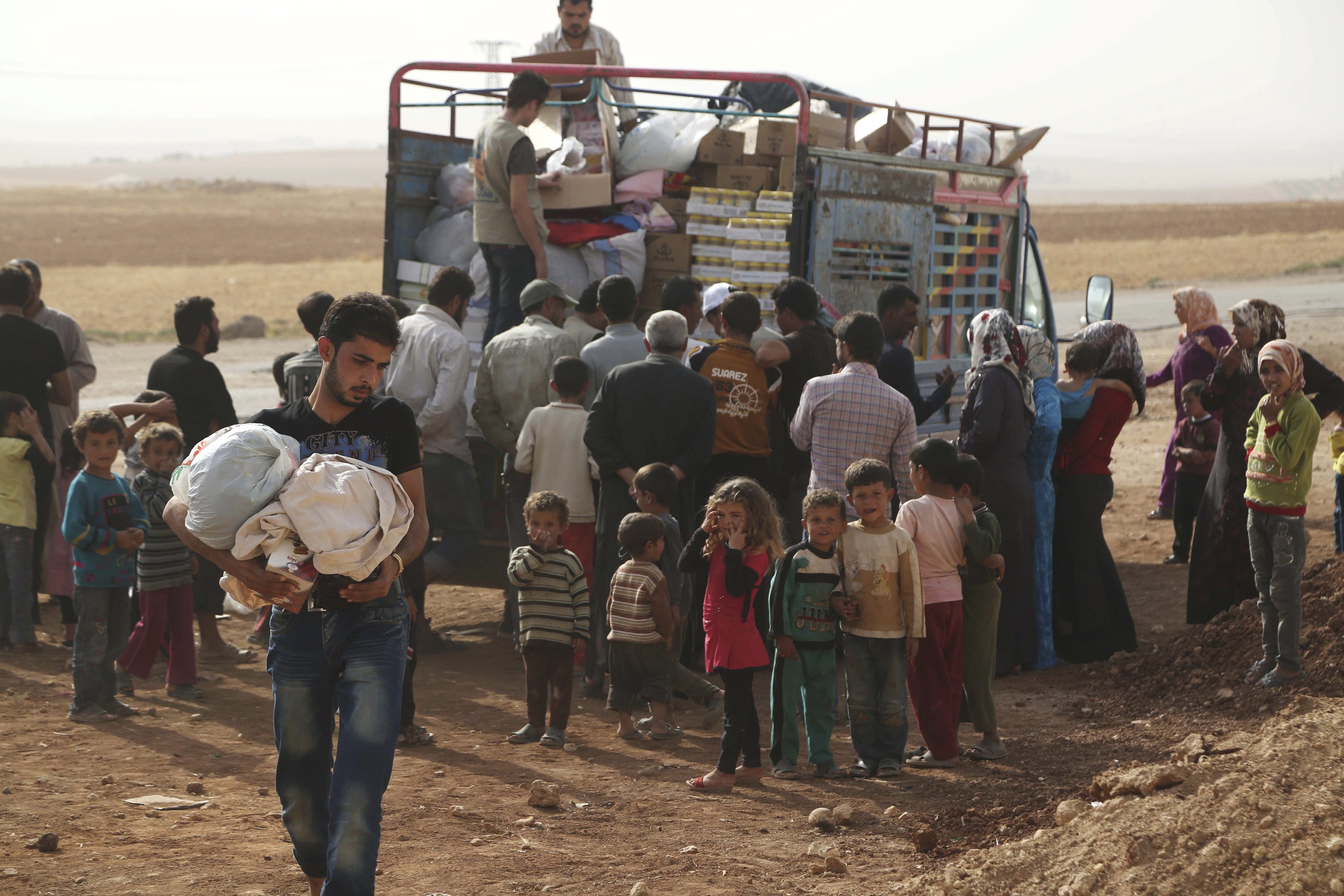 Penduduk Suriah yang melarikan diri dari peperangan di wilayah mereka menerima bantuan kemanusiaan di pinggiran desa Aleppo bagian selatan, Suriah, Rabu (21/10). Perang di Suriah telah membuat sebanyak 35,000 orang mengungsi dari Hader dan Zerbeh di pinggiran barat daya kota Aleppo beberapa hari yang lalu, kata pihak PBB untuk Koordinasi Kemanusiaan (OCHA) pada hari Senin. ANTARA FOTO/REUTERS/Hosam Katan.