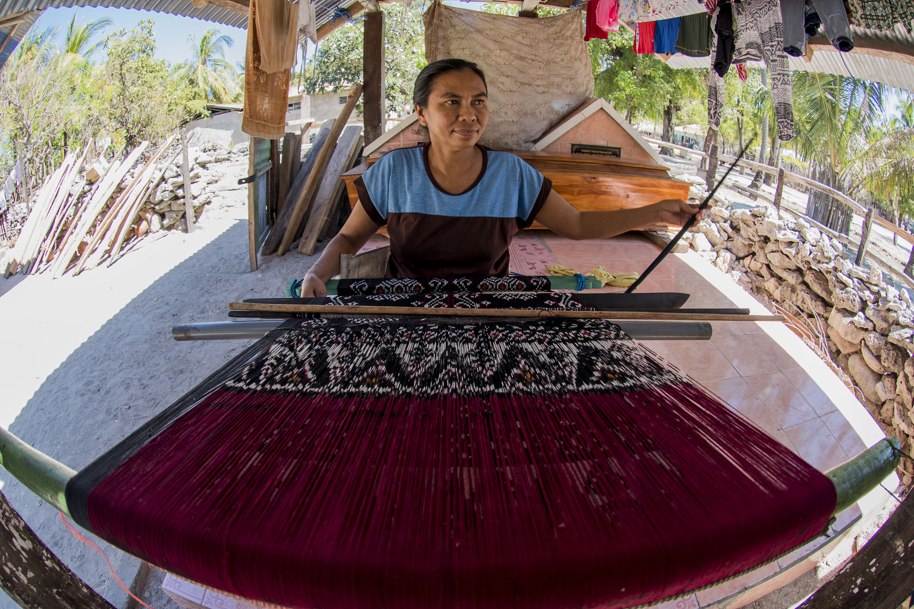 Warga membuat kain tenun ikat di atas makam keluarga, pulau Ndao, Rote, Nusa Tenggara Timur, Kamis (13/8). Pulau tersebut menjadi salah satu tempat pembuat kain tenun ikat khas Rote yang di jual Rp200-600 ribu per kain. ANTARA FOTO/M Agung Rajasa.