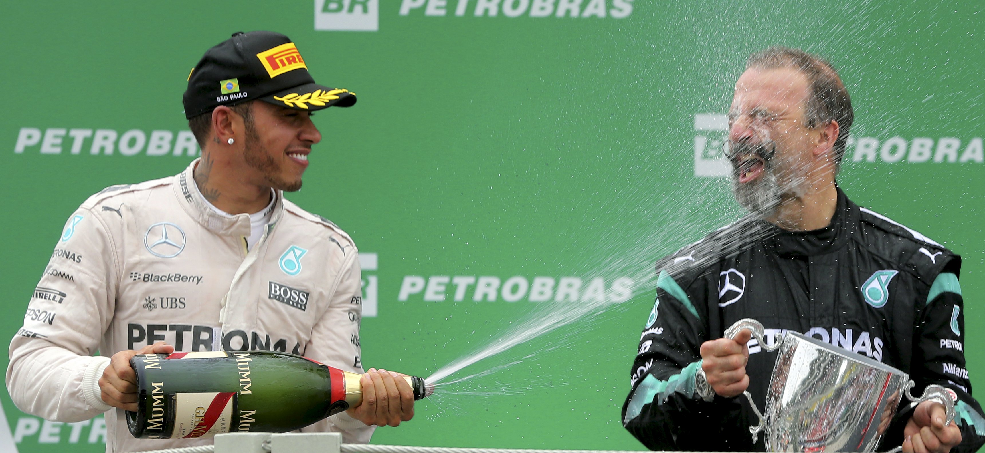 Pembalap Mercedes Formula One Lewis Hamilton (kiri) dari Inggris bergembira dengan teknisi tim balap Mercedes James Weddel setelah Grand Prix F1 Brazil di Sao Paulo, Brazil, Minggu (15/11). ANTARA FOTO/REUTERS/Paulo Whitaker.