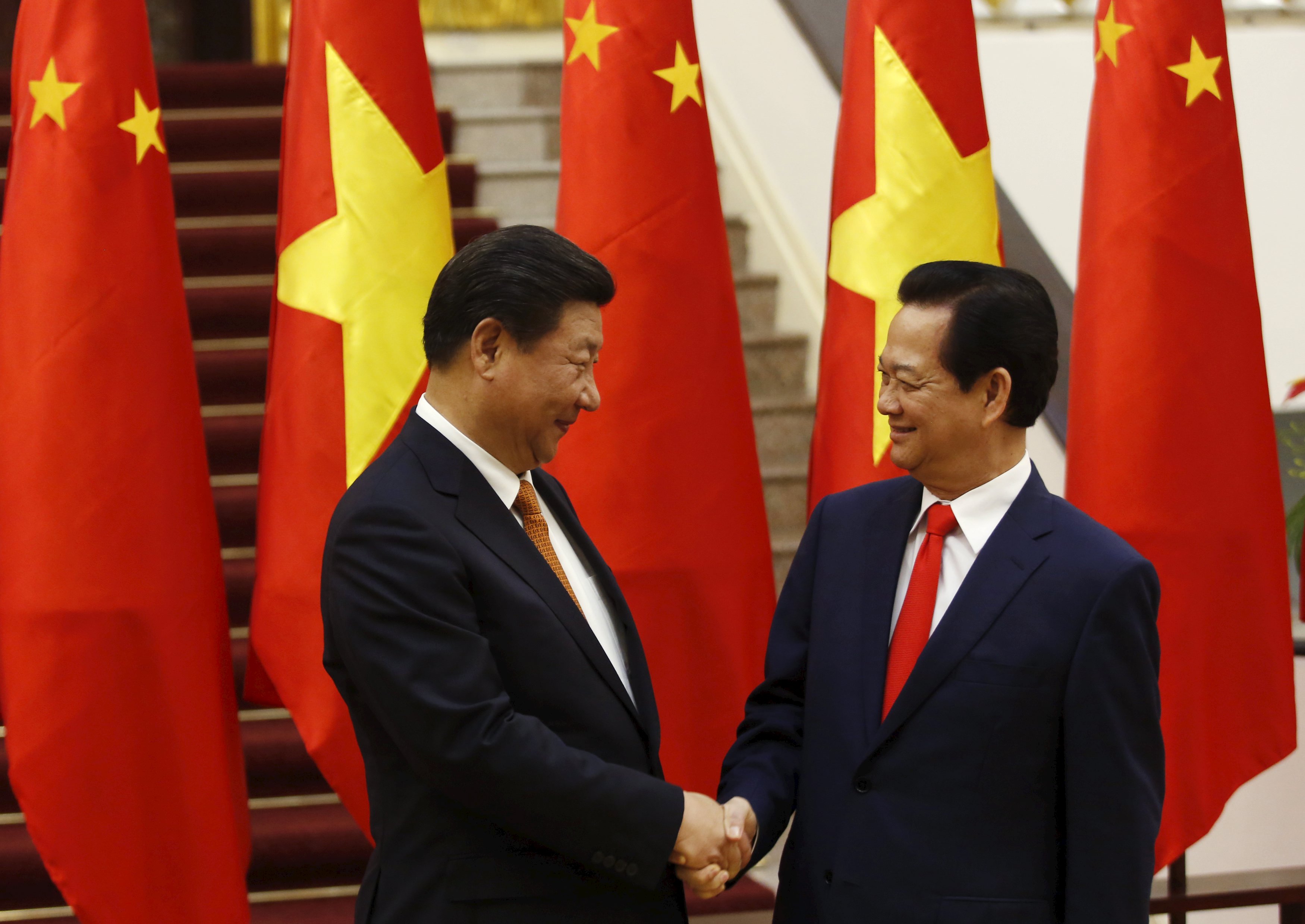 Presiden Tiongkok Xi Jinping (kiri) bersalaman dengan Perdana Menteri Vietnam Nguyen Tan Dung sebelum pertemuan mereka di Kantor Pemerintah di Hanoi, Kamis (5/11). REUTERS/Kham.