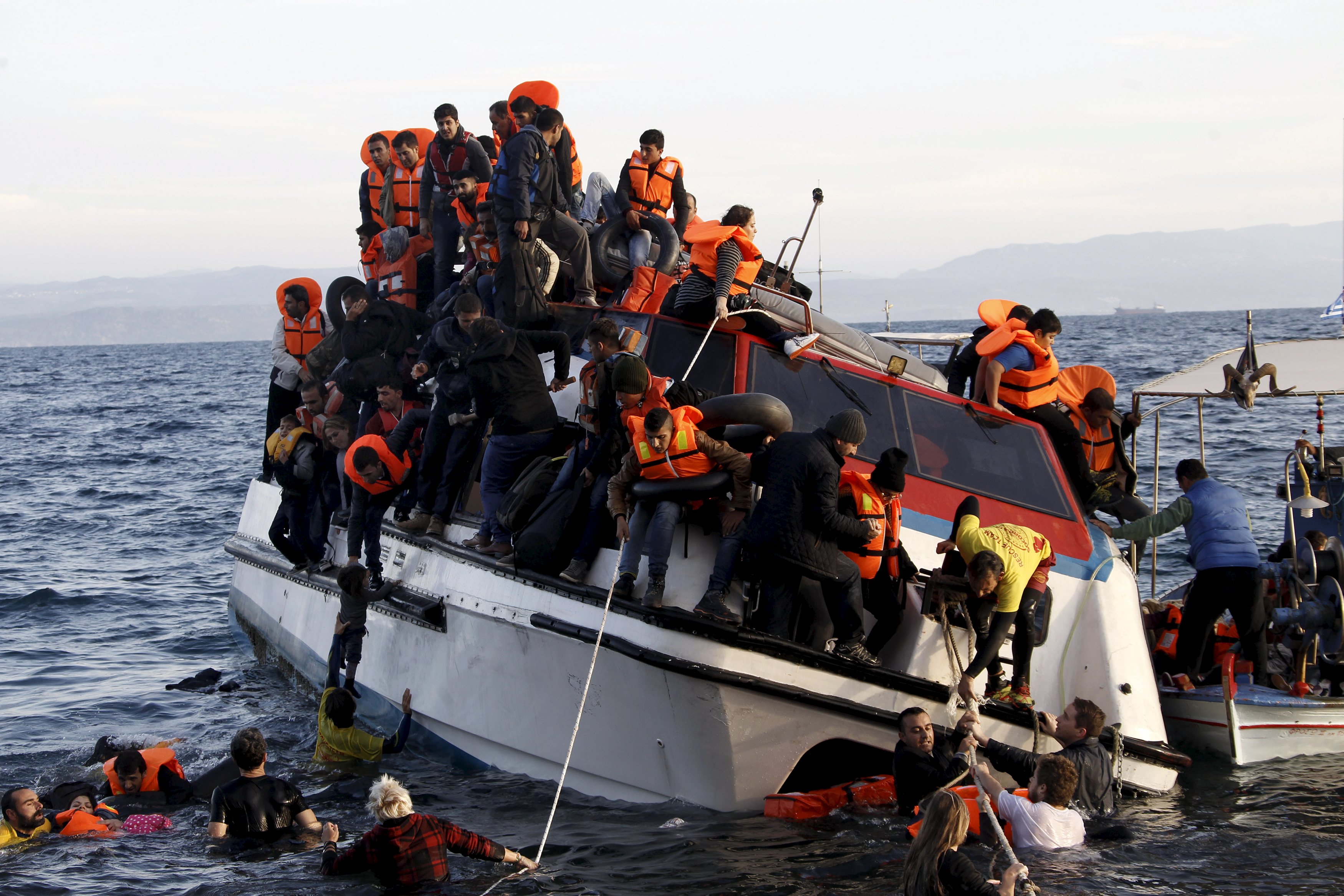 Pengungsi, yang kebanyakan dari Suriah, berjuang meninggalkan perahu berpenumpang sekitar 150 pengungsi saat tiba di Pulau Lesbos Yunani, setelah menyebrangi laut Aegean dari Turki, Jumat (30/10). Tidak ada pengungsi tewas yang menggunakan kapal tersebut, menurut saksi Reuters. Korban tewas tenggelam di laut yang terjadi belakangan ini karena cuaca di laut Aegean semakin memburuk, beralih dari koridor angin laut ke jalur yang mematikan bagi ribuan pengungsi yang menyebrang dari Turki ke Yunani. REUTERS/Giorgos Moutafis.