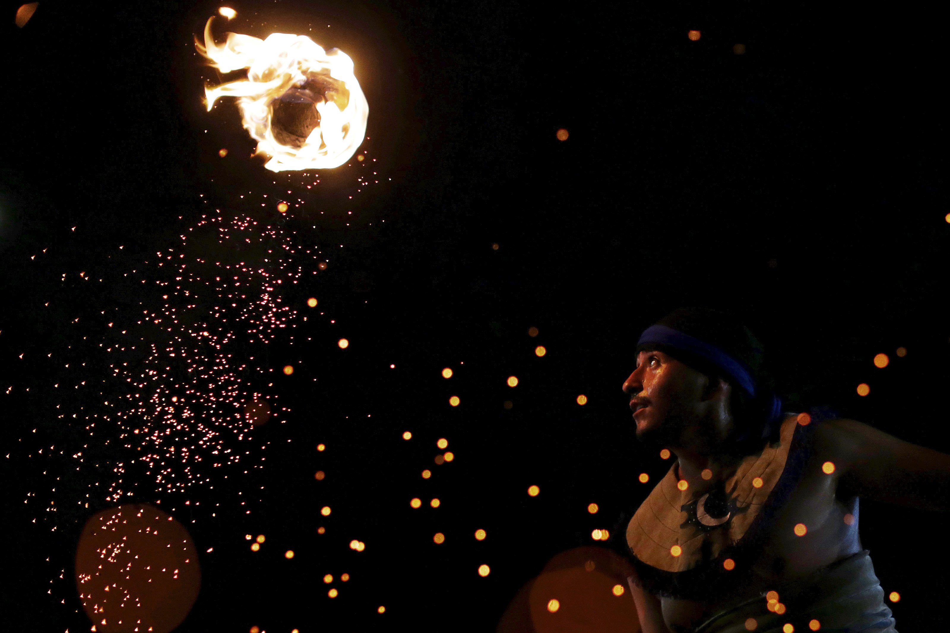 Seorang pria pribumi dari Meksiko menunjukkan permainan Meksiko yang dikenal sebagai "La Batalla" (permainan menggunakan bola api) saat World Games untuk Penduduk Pribumi di Palmas, Brazil, Kamis (29/10). REUTERS/Ueslei Marcelino.