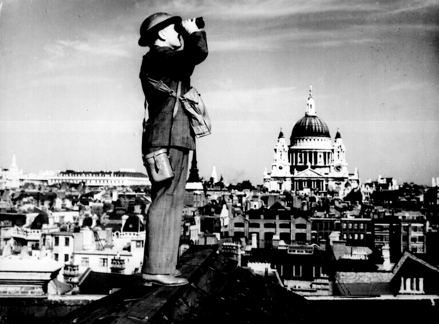 Aircraft spotter on the roof of a building in London. St. Paul's Cathedral is in the background.